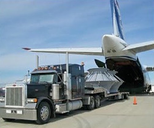 Flatbed truck loading cargo into a freight aircraft